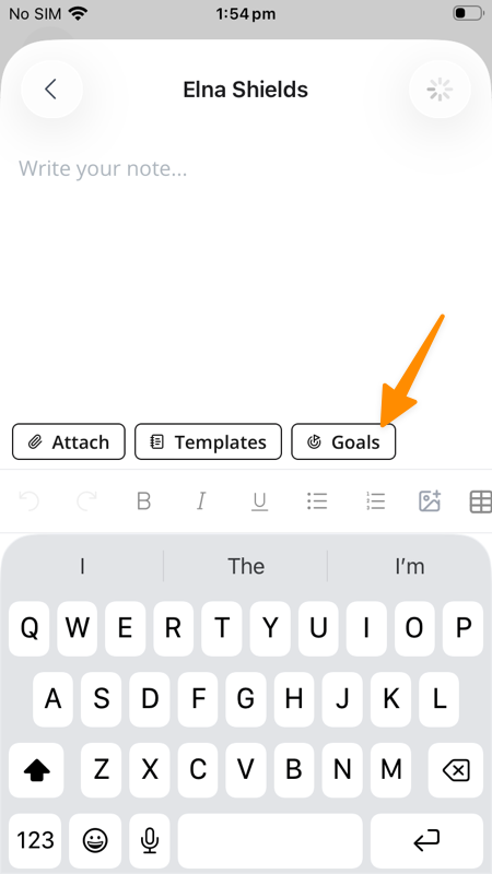 The case note screen in the Support Worker app for Elna Shields, showing an empty note that reads "Write your note...". Three buttons sit in a row below the note — Attach, Templates and Goals — above the formatting toolbar and the keyboard. An orange arrow points to the Goals button at the right of the row.